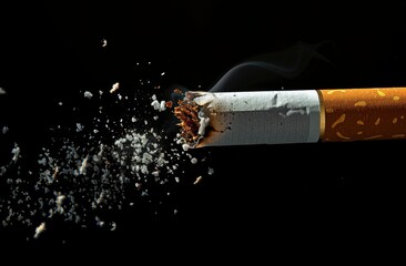 A single cigarette with dropping ash on a black backdrop - obrazy, fototapety, plakaty