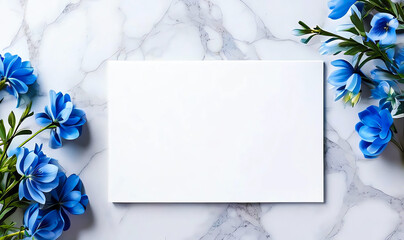 Beautiful work decorated with a blank page and blue flowers on a white marble top view. Copy-space, place for your lettering. 