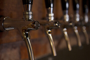 Drinks. Classic metal craft beer taps in the bar.