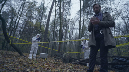 Forensic experts collecting evidence, police investigator writing down case details 