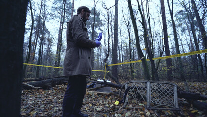 Police detective wears protective gloves to examine the evidence at a crime scene 
