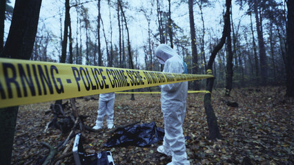 Crime scene marked with police warning tape as coroners investigate a murder 