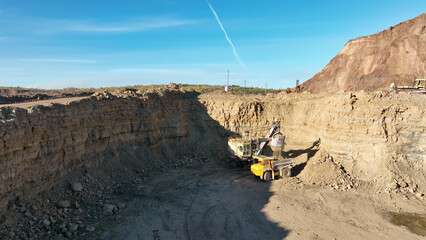 Excavator on earthmoving, aerial view. Open pit mining. Backhoe dig ground in quarry. Excavator...