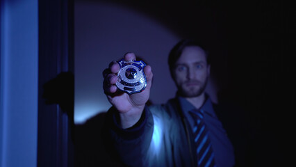 Investigator displays a police badge at the camera, emphasizing crime prevention and law enforcement 
