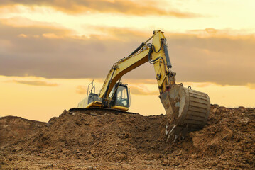 Excavator on dig ground on sunset. Backhoe on earthwork on Construction site. Sewage and drainage...