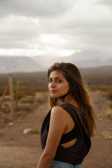 Profile portrait of a young woman with brown hair in the desert at sunset. 