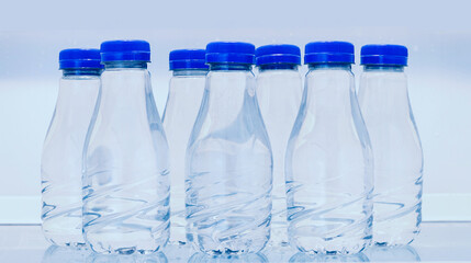 Rows of clean mineral water in transparent bottles with blank lable isolated on white background.