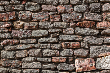Stone texture of a wall in Montenegro. An ancient wall made of brown coloured stones. Background. Template. For design. Horizontal. - obrazy, fototapety, plakaty