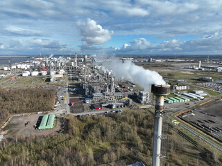 Aerial drone view of a smokestack causing industrial pollution and symbolizing greenhouse gases and climate change.