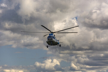 An Mi-8 passenger helicopter flying. Blue cloudy sky in the background