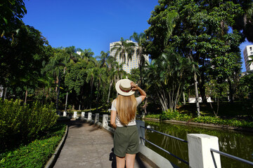 Visiting Belo Horizonte, Brazil. Back view of young woman in the Municiapl Parque Americo Renne Giannetti, a city park in Belo Horizonte, Minas Gerais, Brazil. - obrazy, fototapety, plakaty