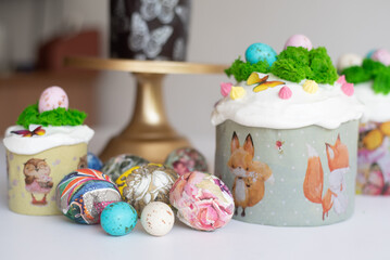 Easter cake decoration with green cream and small colored chocolate eggs, with colorful eggs on light background. Spring Christian holiday of Orthodox believers. 