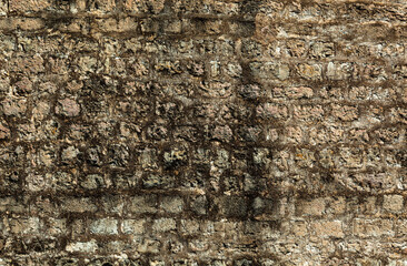 Stone texture of a wall in Montenegro. Ancient wall composed of brown coloured stones. Wet sweat...