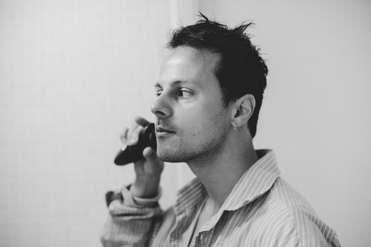 Profile View of Man using electric razor in Monochrome
