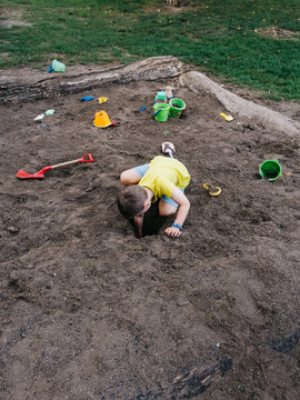 Boy digging a hole in sand