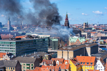 Black smoke drifts over central Copenhagen as historic Copenhagen Stock Exchange goes up in flames. Denmark - obrazy, fototapety, plakaty
