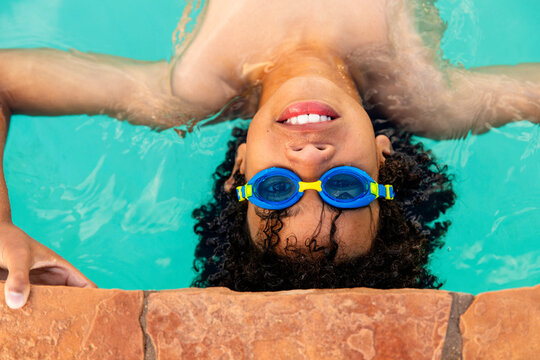 Teen Boy With Goggles In The Pool  Looks At The Camera 