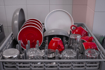 Close-up of washed cups and plates drying in the kitchen. Close-up of clean dishes. Dishwasher. High quality photo