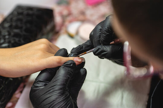 A manicurist woman detailing nails
