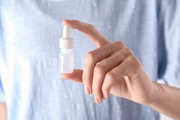 Woman with bottle of medical drops, closeup