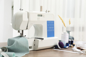 White sewing machine, cloth and craft accessories on wooden table indoors
