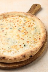 Delicious cheese pizza on beige textured table, closeup