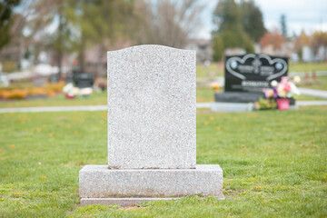 A large blank tombstone in a cemetery. 