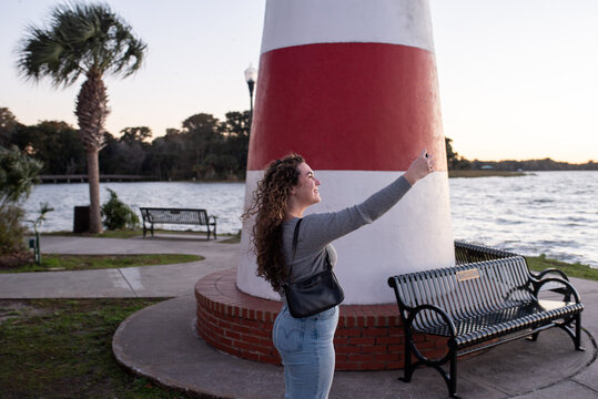 Girl taking selfies by a lake