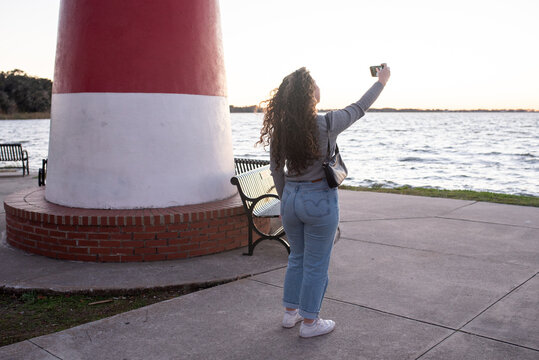 Girl taking selfies by a lake