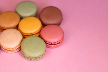 Colorful macarons on pink background. Selective focus.