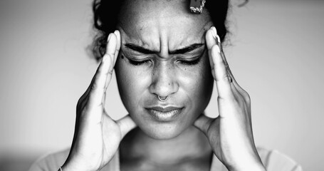 Overwhelmed young African American woman pressing head side temples feeling mental pressure and anxiety, close-up face of person feel stress and indignation - obrazy, fototapety, plakaty