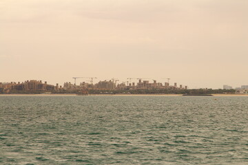 A body of water with a city in the background