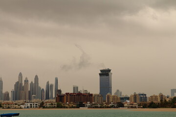 A city skyline with a few tornados in the sky