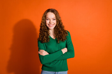 Photo of cool confident lady dressed green shirt smiling arms crossed isolated orange color background
