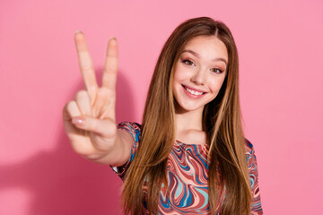 Portrait of pleasant nice teen with long hairstyle dressed colorful shirt showing you v-sign say...