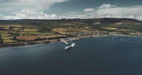 Scotland, Brodick Ferry Terminus aerial panoramic shot of ship crossing, Arran Island. Beautiful passenger ferry go from harbor at Firth-of-Clyde Gulf to mainland. Cinematic scenery view