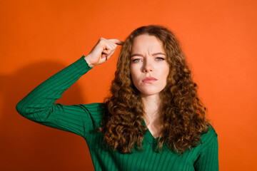 Photo of doubtful uncertain lady dressed green shirt forget important thing isolated orange color background