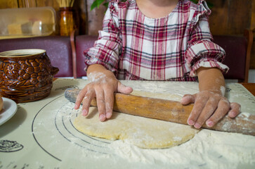 child with dough in the kitchen, girl sculpting, helping mom, rolling out dough, preparing food, rural interior, boho kitchen, atmospheric photos with a child in the kitchen