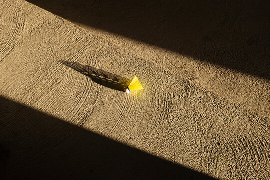 Neon green badminton ball laying on a grey concfrete wall