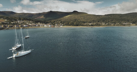 Scotland's ocean coast sailboats aerial view in coastal water near Brodick village, Arran Island....
