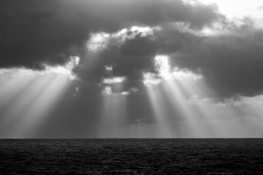 Dramatic light rays on the ocean at sunset 
