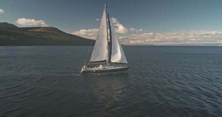 Slow motion of racing yacht at open sea aerial. Passengers on cruise sail boat. Serene seascape of...