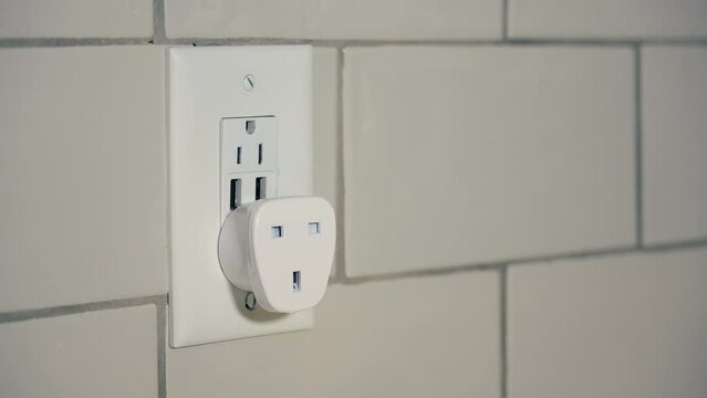 A closeup view of a European grounded plug-in electrical outlet power converter. This adapts a type G plug from the United Kingdon, UK, Singapore, Malaysia, UAE, Ireland, and Hong Kong to the USA.