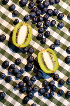 White and green background with fresh fruit kiwi and blueberry