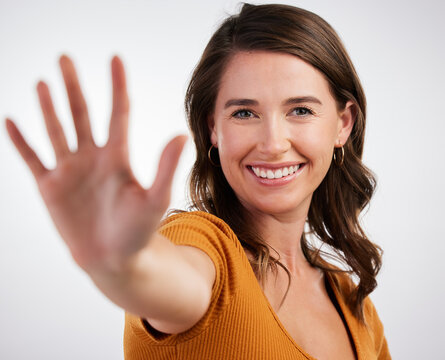 Hand, hello and portrait of happy woman in studio for volunteering, donation or promotion on white background. Palm, wave or friendly model with greeting emoji for attention, stop or sign up reminder