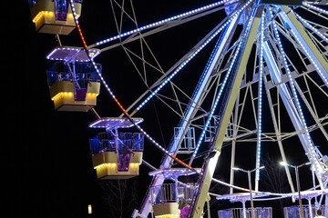 Ferris wheel at night under the light of a searchlight