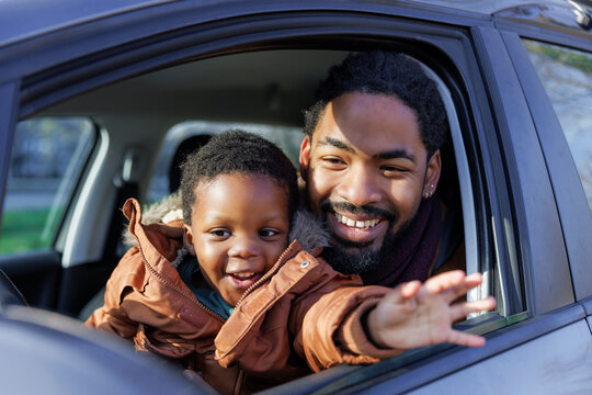 Portrait of father and son sitting on driver's seat in car - Powered by Adobe