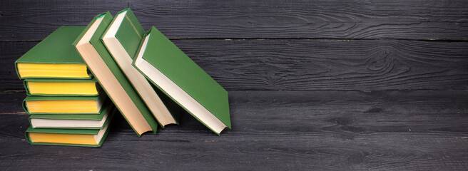 Books on wooden table, black board background. Back to school. Education business concept....