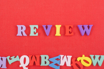 REVENUE word on red background composed from colorful abc alphabet block wooden letters, copy space...
