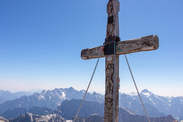 Summit cross of majestic mountain peak Mangart (Mangrt) in Julian Alps, Friuli Venezia Giulia,...